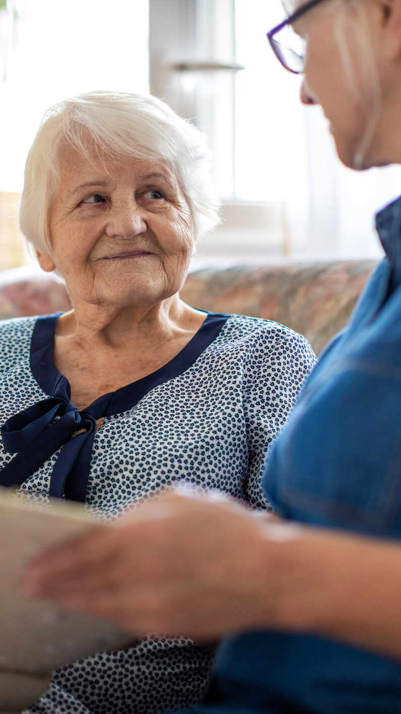 A caregiver and a senior discussing proper post-hospitalization care 