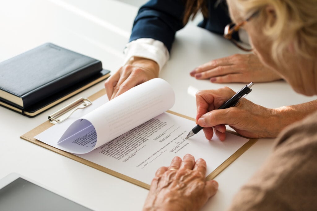 Woman with glasses signing document