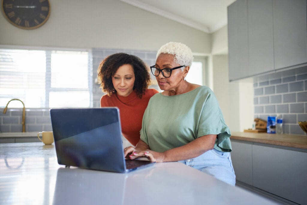 Two women research digital legacy on a laptop.
