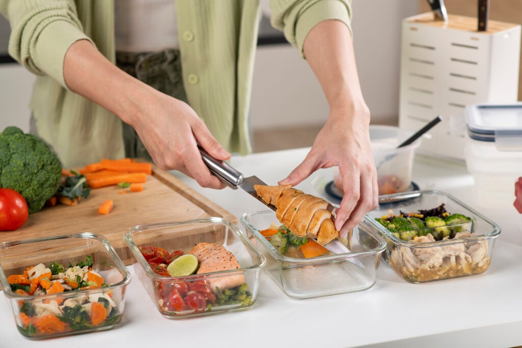 Woman preparing healthy homemade meal prep, with fresh, healthy food at home.