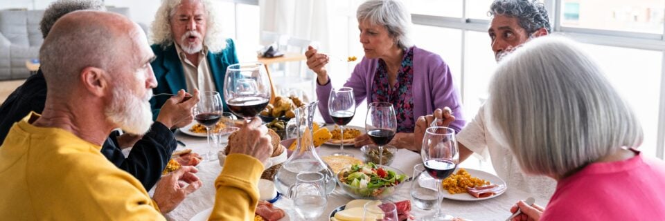 group of friends gather at table to enjoy mediterranean meal